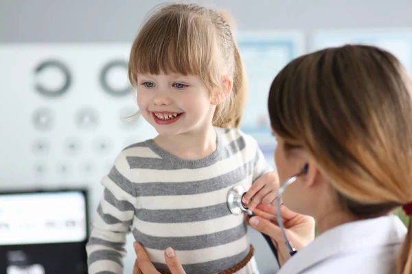 Kobieta lekarz pracujący z cute uśmiechnięta dziewczynka w jej biurze — Zdjęcie stockowe