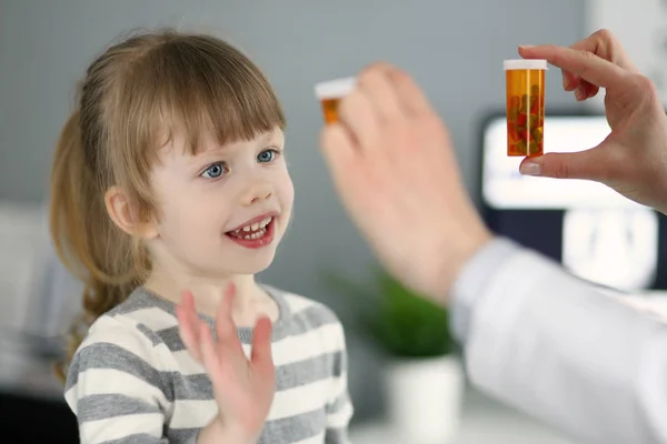 Linda niña paciente divirtiéndose seleccionando una botella de medicamentos —  Fotos de Stock