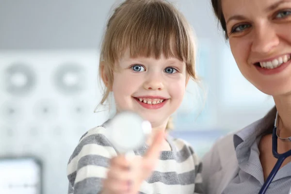 Kinderarzt hält und umarmt kleine süße Patientin — Stockfoto