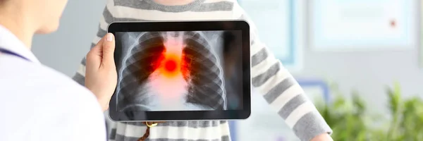 Femmina medico esaminando bambina con ultra moderno tablet pc scansione che mostra problemi di polmonologia — Foto Stock