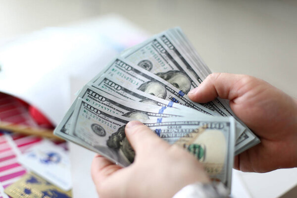 Male hands counting money from huge pack