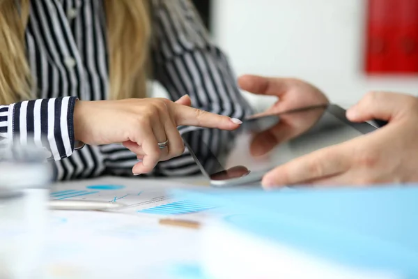 Man offering female client tablet pc to confirm deal