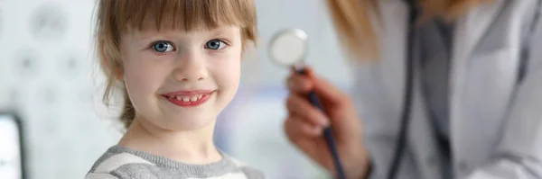 Sorrindo bonito pequeno paciente interagindo com médico feminino — Fotografia de Stock