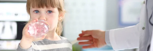 Söt liten flicka att få vatten i Doctor Office — Stockfoto