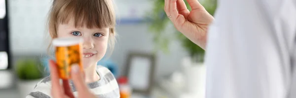 Söt liten patient flicka ha kul att välja en flaska mediciner — Stockfoto