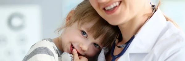 Médico pediátrico sosteniendo y abrazando a una niña linda paciente — Foto de Stock