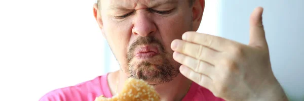 Nešťastný člověk očichává podezřelý Burger s kontrolou čerstvosti — Stock fotografie