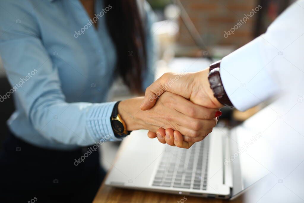 Man and a woman in office shake hands