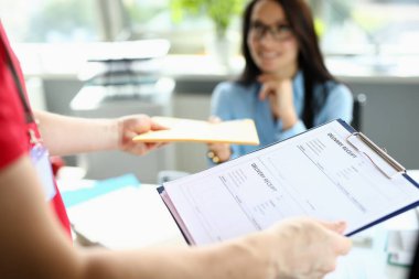 Ofisteki kadın postacıdan paket alıyor.