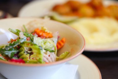 Sebze salatası ve yanında meze olan ikinci et yemeği..