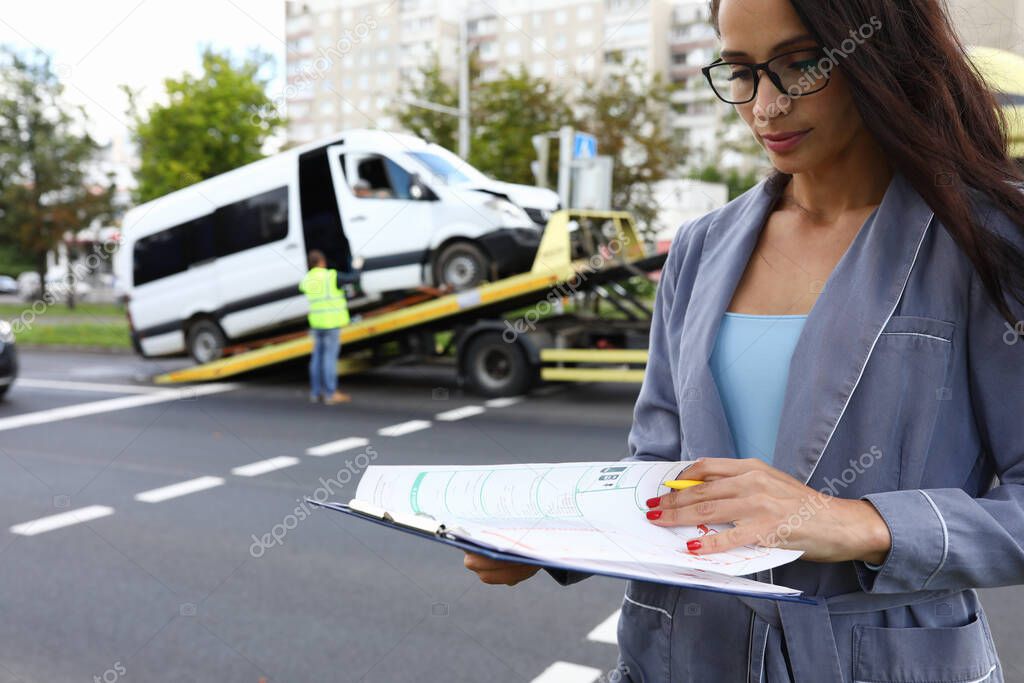 Female agent fills out insurance at the scene of accident.