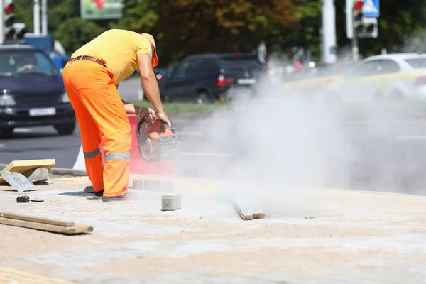 Male worker holds gas cutter in his hands and cuts concrete. — Stock Photo, Image