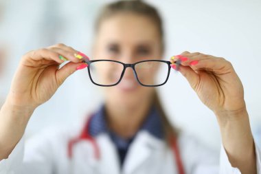 Kadın doktor elinde gözlük tutuyordu.