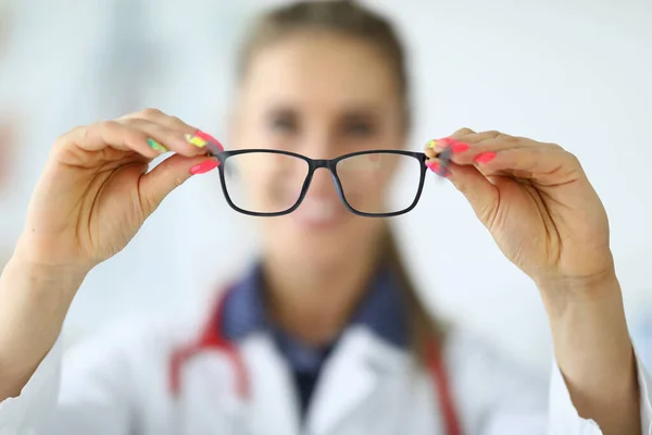 Mujer doctora sosteniendo gafas en sus manos de cerca — Foto de Stock