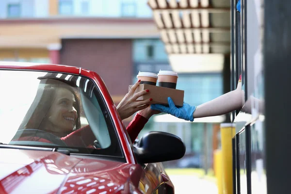 Kvinna i cabriolet hämtar te och kaffe i McDrive — Stockfoto