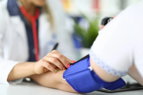 Médico mujer mide la presión a paciente en consultorio médico . —  Fotos de Stock