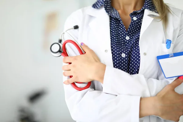 Arzt mit Stethoskop in der Hand steht mit verschränkten Armen — Stockfoto