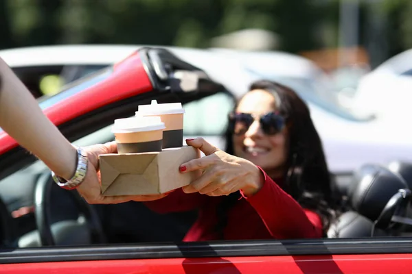 Mujer en coche recoge café de primer plano mensajero — Foto de Stock