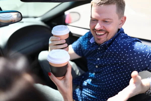 Man med kvinna som håller kaffe och skrattar i bilen — Stockfoto