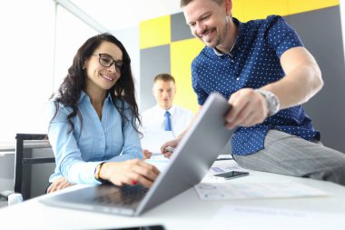 Başarılı iş ekibi laptopta yeni stratejileri tartışıyor.