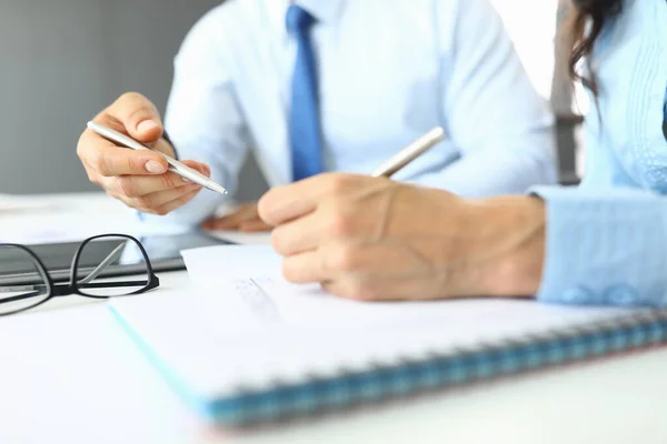 Les mains des femmes et des hommes tiennent des stylos au bureau sur des documents. — Photo