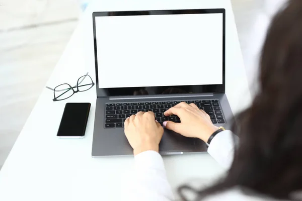 Женщина работает на ноутбуке очки лежат рядом крупным планом — стоковое фото