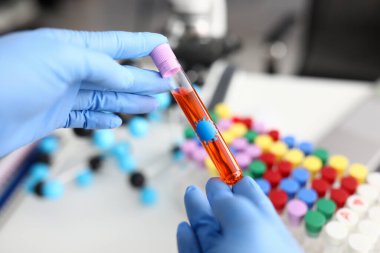 Doktor laboratuvar asistanı elinde sıvı ile test tüpü tutuyor.
