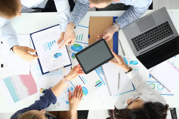 İş adamları ve iş kadınları çelik fabrikasında ticari göstergeleri tartışıyor.