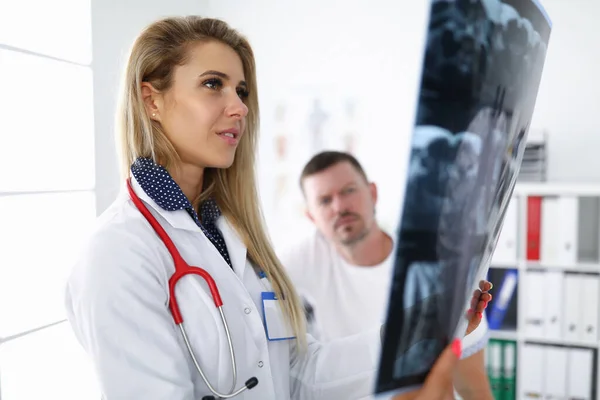 Mulher médico examina um raio-x com paciente. — Fotografia de Stock