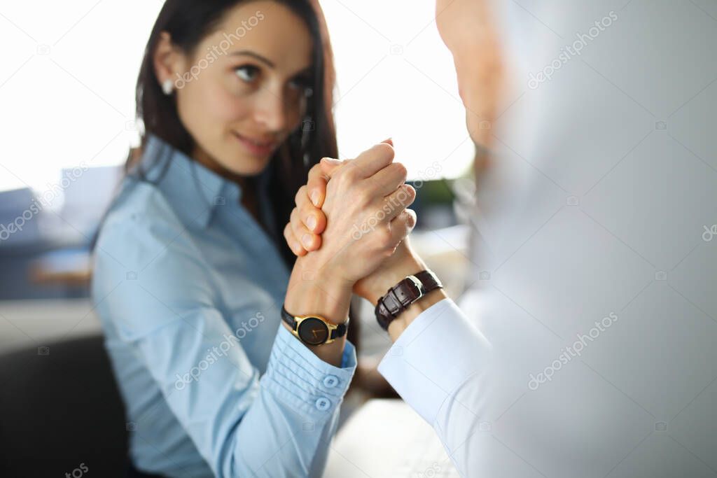 Businesswoman is competing in her arms with man.