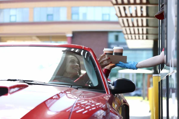 Kvinnan i bilen plockar upp sitt kaffe koncept — Stockfoto