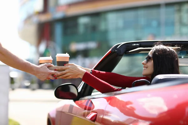 Mensajero entrega café a la mujer en el primer plano del coche — Foto de Stock