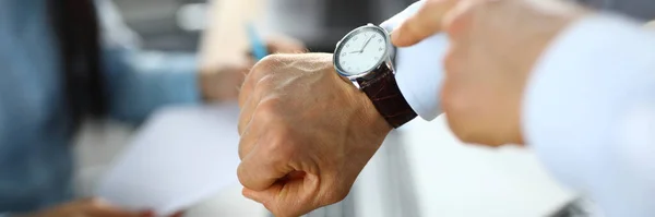El hombre en la oficina muestra un dedo en el reloj — Foto de Stock