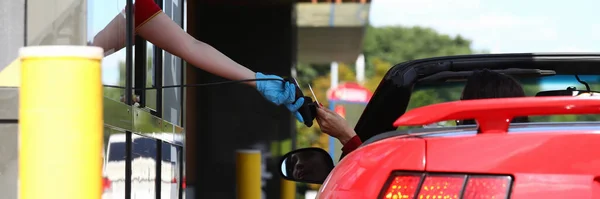 Frau im Cabrio zahlt am Bezahlpunkt mit Bankkarte. — Stockfoto