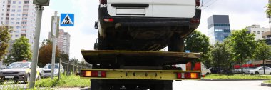 Minibüs trafik lambasında bir çekicinin üzerinde duruyor.