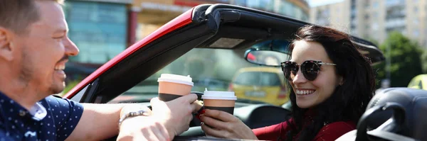 Frau im Auto hält Kaffee und lacht mit Mann — Stockfoto