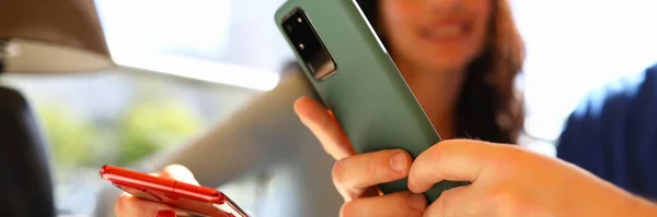 Hombre y mujer están sentados en la cafetería y mirando los teléfonos inteligentes — Foto de Stock