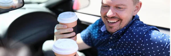 Homem com mulher segurando café e rindo no carro — Fotografia de Stock