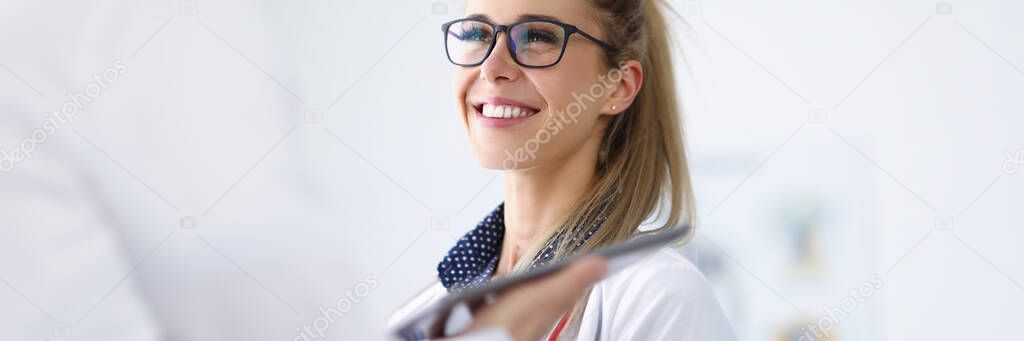 Female doctor smiles and communicates with colleague.