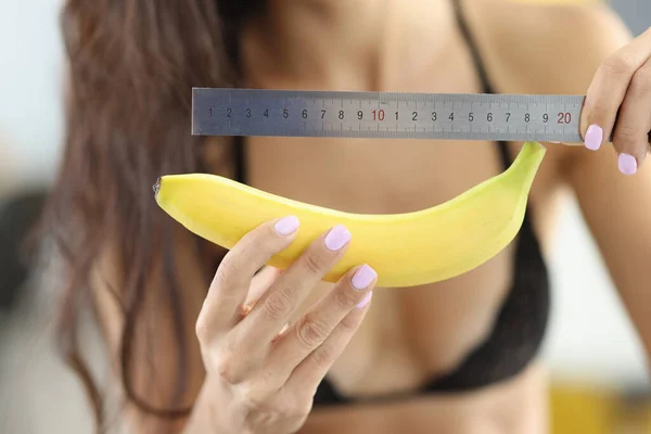 Donna in biancheria intima tiene banana e righello. — Foto Stock