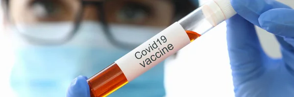 Onderzoeker houdt kolf met covid-19 vaccin close-up — Stockfoto