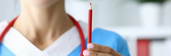 Mujer doctora sostiene lápiz rojo en su mano . — Foto de Stock