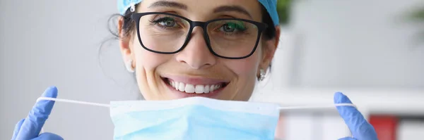 Femme médecin souriant dans un masque médical de protection et des gants portrait. — Photo