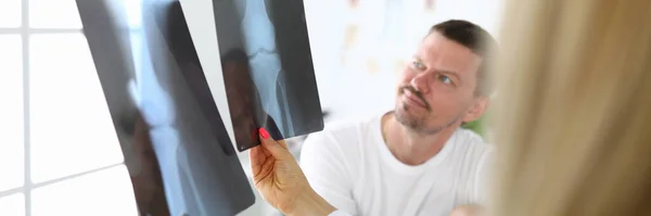 Пациент мужского пола вместе с врачом осматривает рентген. — стоковое фото