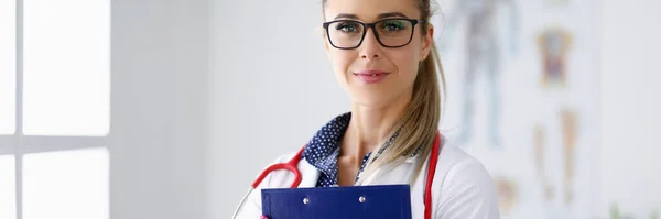 Medico ufficiale sorride e tiene appunti nelle sue mani. — Foto Stock