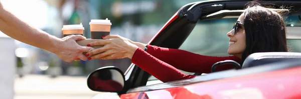 Mensajero entrega café a la mujer en el primer plano del coche — Foto de Stock