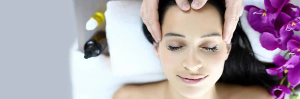 Massage therapist makes woman on massage table an acupressure head massage — Stock Photo, Image