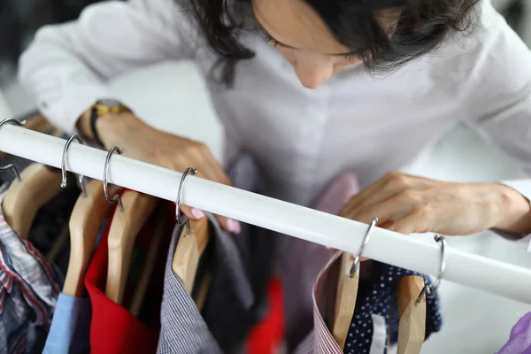 Wanita muda memilih kemeja pada gantungan di lemari pakaian di closeup rumah — Stok Foto