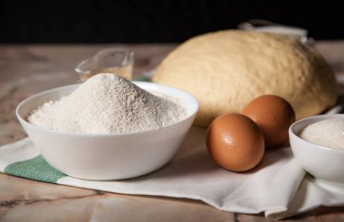 Fırın malzemeleri. Masada un, yumurta ve hamur hamuru var.