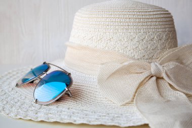 Beyaz arka planda güneş gözlüğü ile Hasır şapka